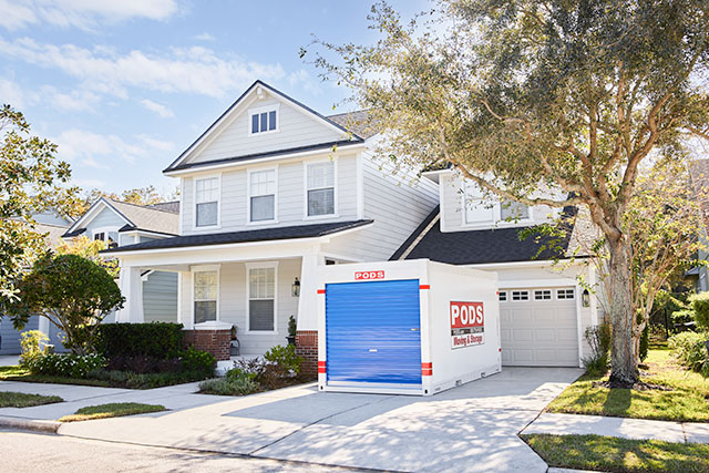 A PODS storage container siting in the front driveway of a home